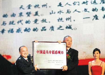 在杭州大剧院举行的颁奖仪式上，杭州平民英雄孔胜东（左）为杭州市长蔡奇颁奖。图片来源：今日早报 记者 胡元勇 摄